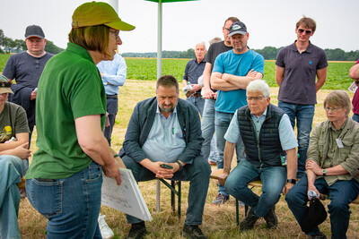Annette Hoffmann (l., Pflanzenbau) beim Feldtag zum Thema Landwirtschaft und Wasserschutz; unter den Zuh&ouml;rern sind  Landvolk-Pr&auml;sident Dr. Holger Hennies (M.) und rechts neben ihm CDU-Agrarexperte Dr. Frank Schm&auml;deke.